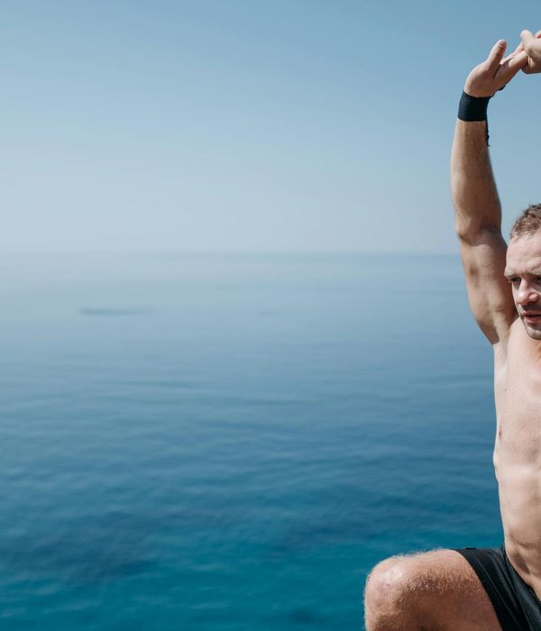 Person feeling energized and stretching outdoors with nature background.