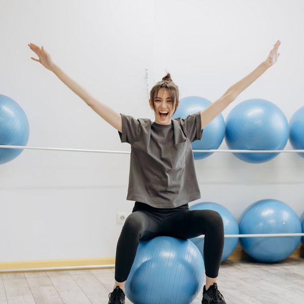Woman practicing a gentle mobility exercise in a bright room.